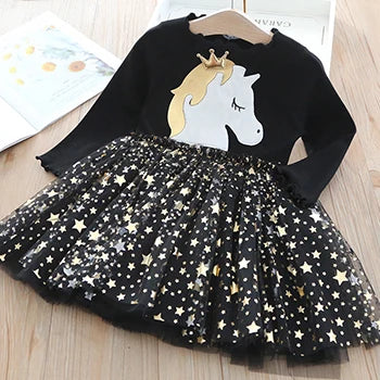 Mädchen in einem rosa Riesen Einhorn Kleid mit Sternen und Mesh-Rock, lächelnd in einer sommerlichen Umgebung.