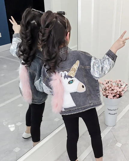 Mädchen in einer glitzernden Einhorn Jacke aus Jeansstoff mit Pailletten und Stickereien im Cowboy-Stil