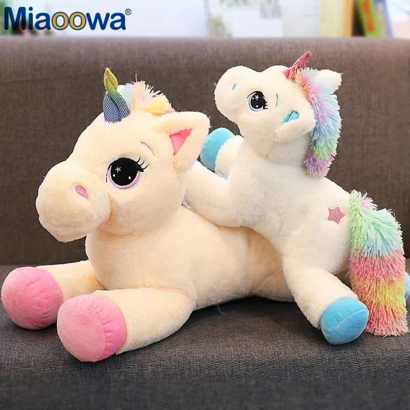 Blaue Einhorn Tasche, 40 cm groß, aus Plüsch, mit bunter Regenbogen-Mähne und Schweif, liegend und lächelnd.