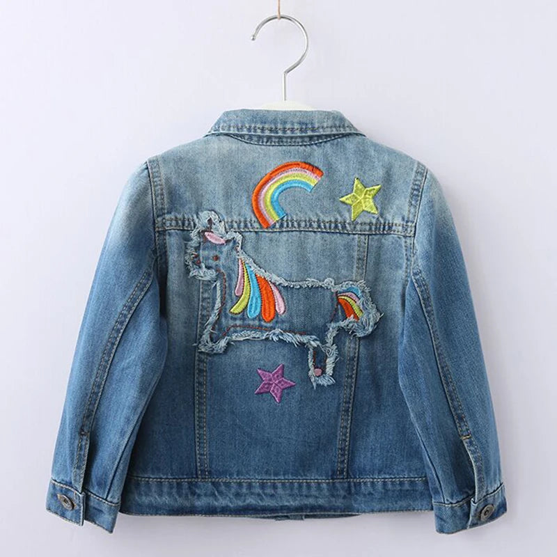 Mädchen in einer blauen Denim Einhorn Jacke mit bunter Regenbogen-Stickerei