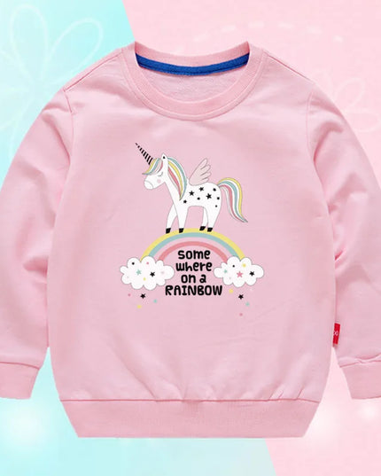 Mädchen in einem leuchtend pinken Einhorn Pullover mit einem fröhlichen Einhorn-Motiv