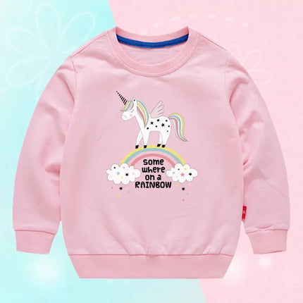 Mädchen in einem leuchtend pinken Einhorn Pullover mit einem fröhlichen Einhorn-Motiv
