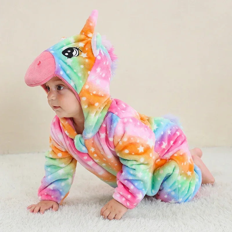 Baby in einem flauschigen Regenbogen Einhorn Kigurumi Kostuem aus Flanell mit Kapuze und Horn