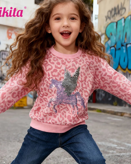 Mädchen trägt einen rosafarbenen Einhorn Pullover mit Leopard-Print und reversiblen Einhorn-Pailletten auf der Brust