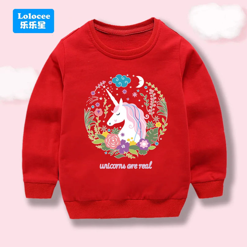 Mädchen trägt einen roten Einhorn Hoodie mit einem floralen Einhorn-Print und lächelt glücklich in die Kamera.