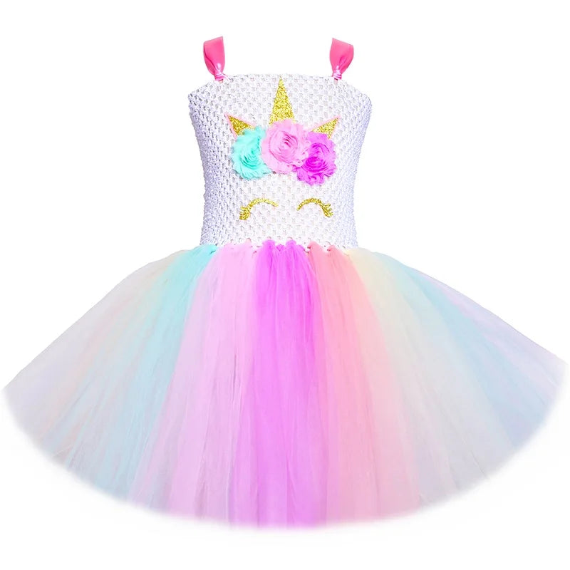 Mädchen in einem schulterfreien Einhorn Prinzessinnen Tutu Kleid in Pastell-Regenbogenfarben mit Blumen-Applikationen.