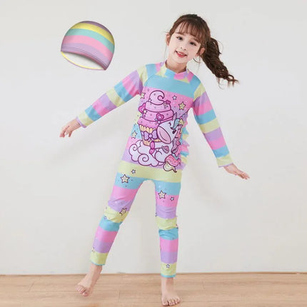 Mädchen in einem farbenfrohen Einhorn Schwimmanzug mit Regenbogen und Sternen, bereit zum Schwimmen und Planschen.
