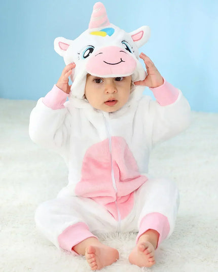 Baby in einem flauschigen weißen Einhorn Kigurumi Kostuem aus Flanell mit Kapuze und Horn