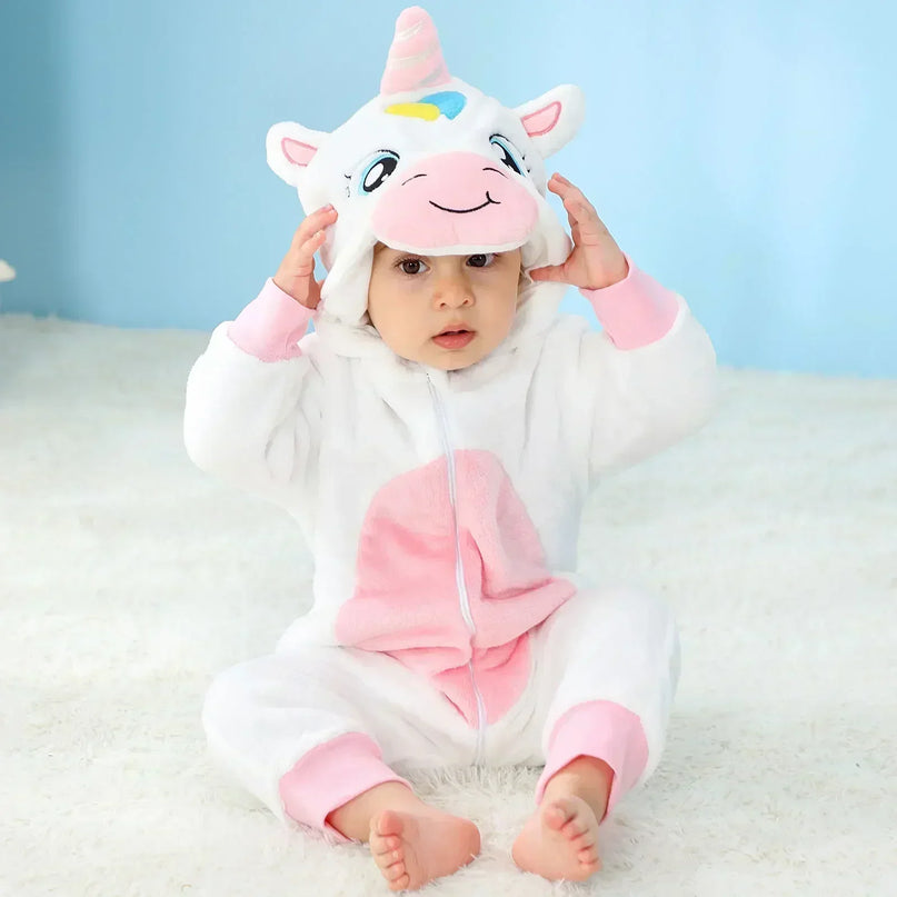 Baby in einem flauschigen weißen Einhorn Kigurumi Kostuem aus Flanell mit Kapuze und Horn