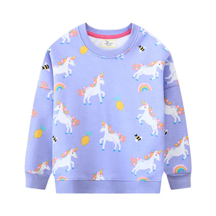 Mädchen in einem pinken Riesen Einhorn Sweatshirt mit einem großen, farbenfrohen Einhorn-Motiv auf der Vorderseite, lächelnd.