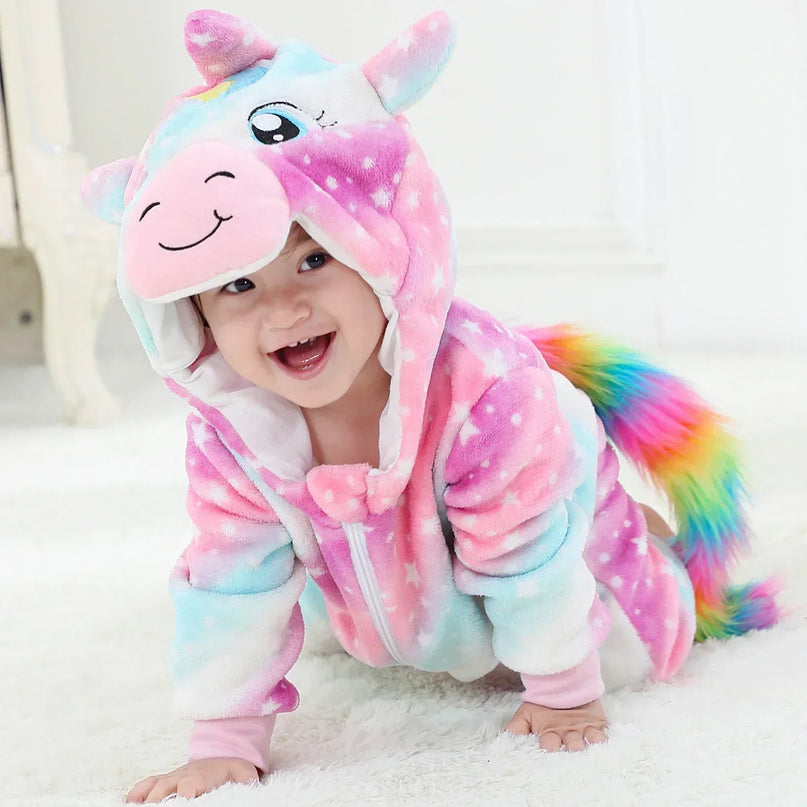 Baby in einem flauschigen pinken Einhorn Kigurumi Kostuem aus Flanell mit Kapuze und Horn