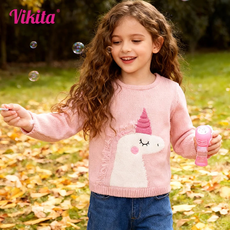 Mädchen in einem rosafarbenen Einhorn Pullover mit Rundhalsausschnitt und Einhorn-Motiv