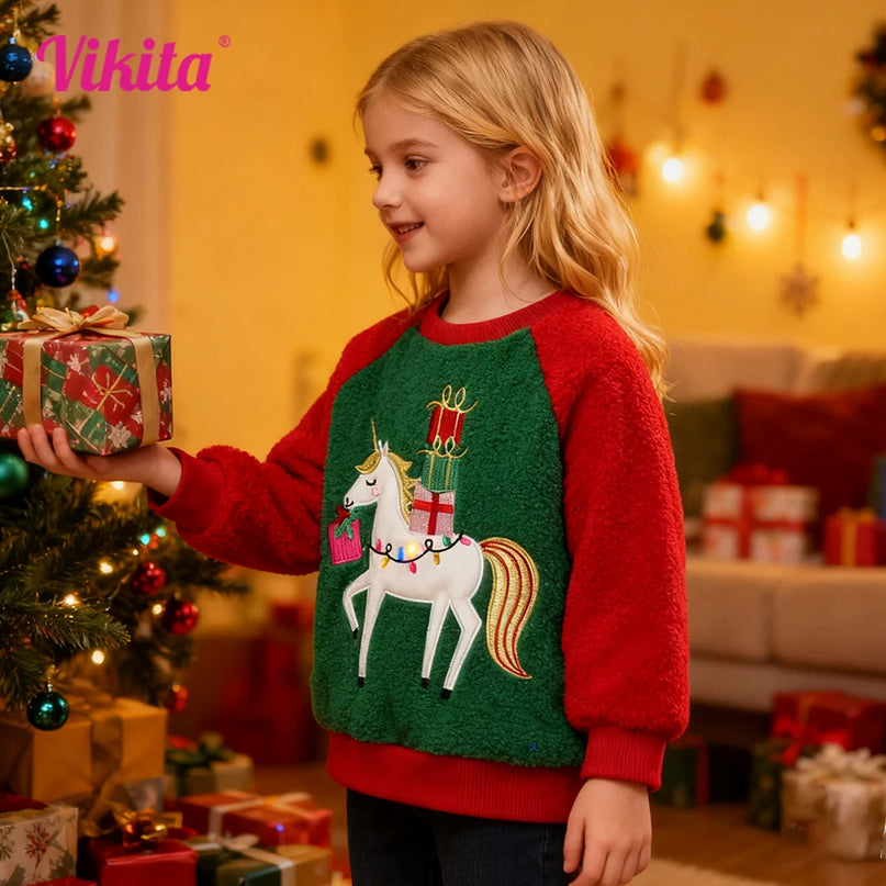 Mädchen trägt einen festlichen, rot-grünen Einhorn Pullover mit dicker Applikation eines Einhorns und Sternen, perfekt für Weihnachten