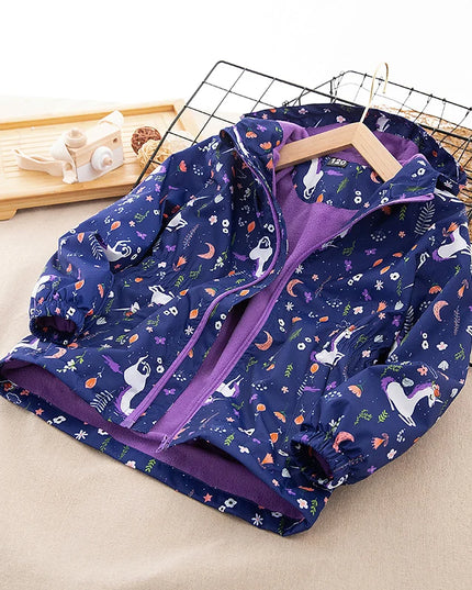 Mädchen in einer lila, wasserdichten und winddichten Einhorn Jacke mit Kapuze und floralem Muster