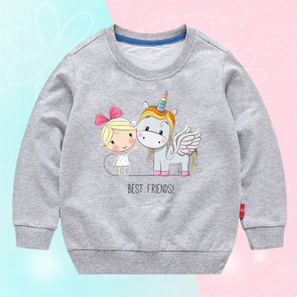 Mädchen trägt einen hellgrauen Einhorn Pullover mit einem großen, niedlichen Cartoon-Einhorn-Motiv auf der Brust, aus weichem Stoff.