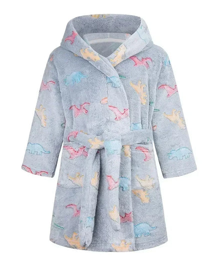 Kind in einem niedlichen, bunten Einhorn Pyjama mit Kapuze, lächelnd und spielend