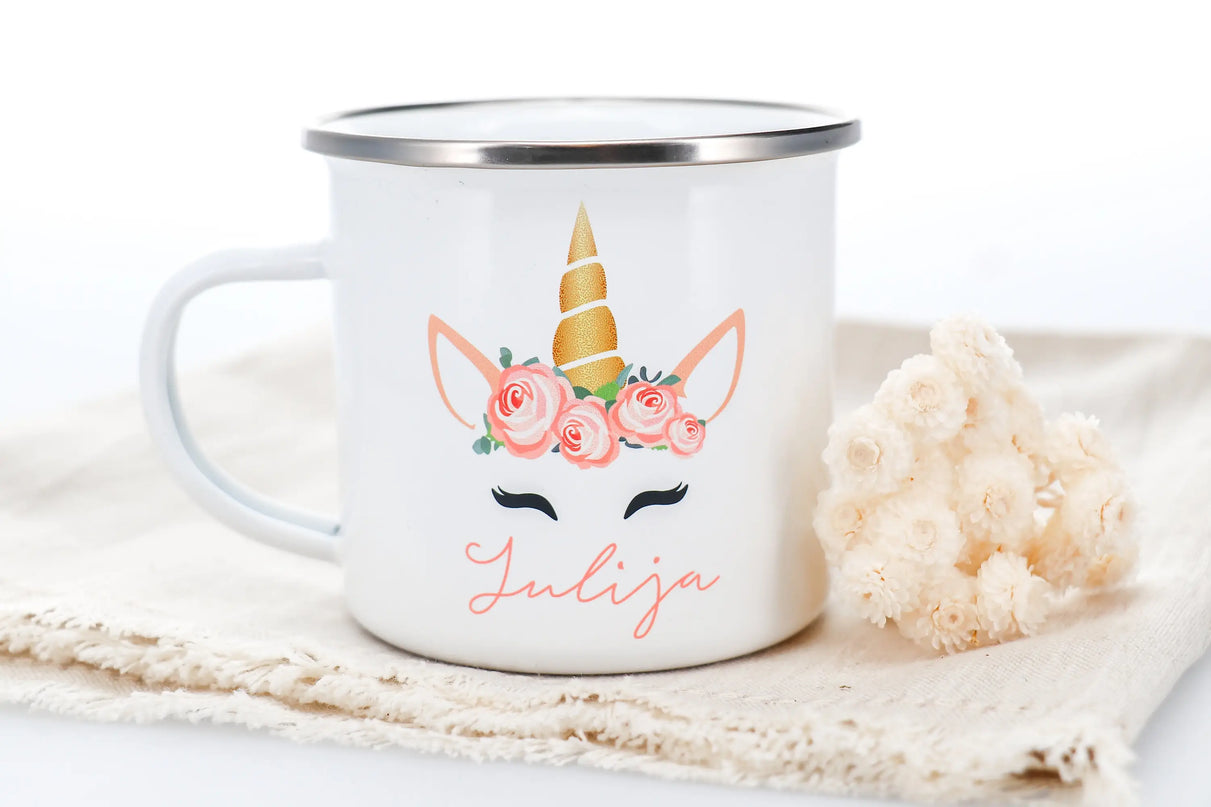 Eine personalisierte weiße Emaille Einhorn Tasse mit einem niedlichen Einhorn-Aufdruck und Namen, ideal für Kinder.