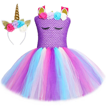 Mädchen in einem regenbogenfarbenen Einhorn Kostuem mit pastellfarbenen Blumen und einem passenden Stirnband