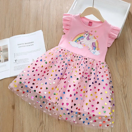 Mädchen in einem pinkfarbenen Riesen Einhorn Regenbogenkleid mit fliegenden Ärmeln und glitzerndem Mesh-Rock, lachend und tanzend.
