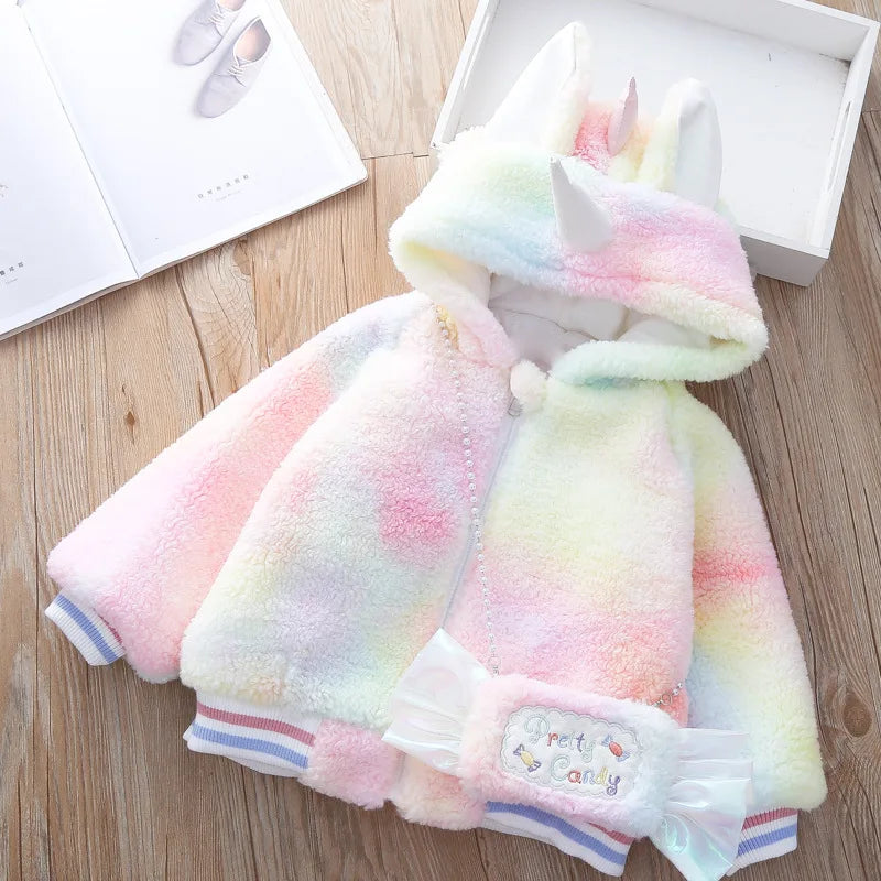 Mädchen in bunter Einhorn Winterjacke mit Kapuze und passender Einhorn Tasche
