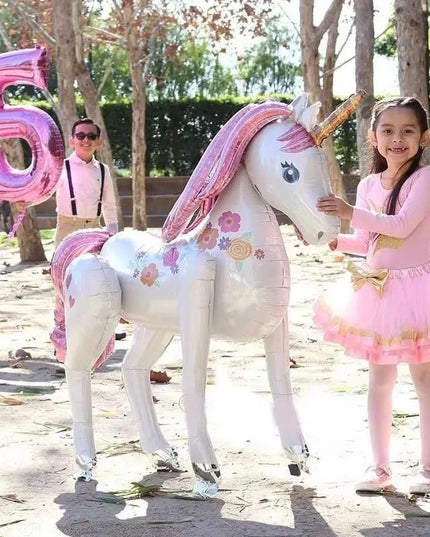 Ein großer, farbenfroher Einhorn Tierballon aus Aluminiumfolie, der lächelnd in die Kamera blickt und eine festliche Stimmung verbreitet
