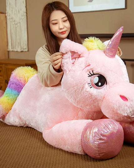 Rosa Kawaii Einhorn Tasche, riesig, aus Plüsch, mit bunter Mähne und Schweif, in liegender Position, auf weißem Hintergrund.