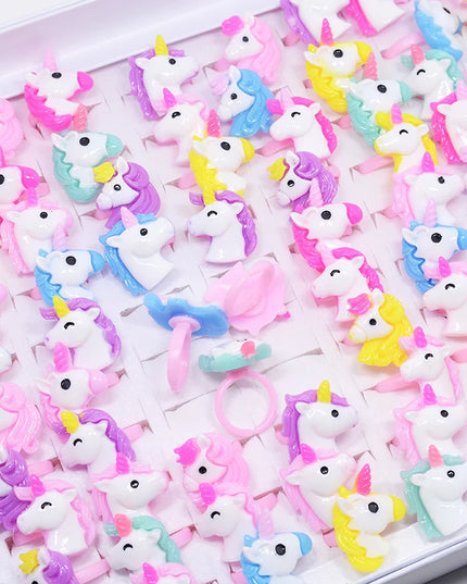 Set aus 20 bunten Einhorn Ringen mit Tiermotiven für Kinder, aus Resin, auf einem Display