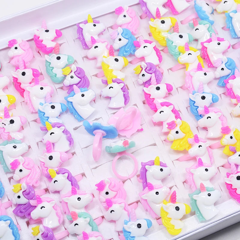 Set aus 20 bunten Einhorn Ringen mit Tiermotiven für Kinder, aus Resin, auf einem Display