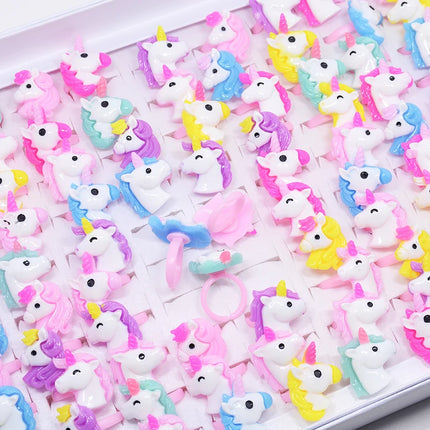 Set aus 20 bunten Einhorn Ringen mit Tiermotiven für Kinder, aus Resin, auf einem Display