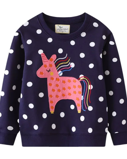 Mädchen in einem weißen Riesen Einhorn Sweatshirt mit einem farbenfrohen, modernen Einhorn-Motiv, das fröhlich lacht.