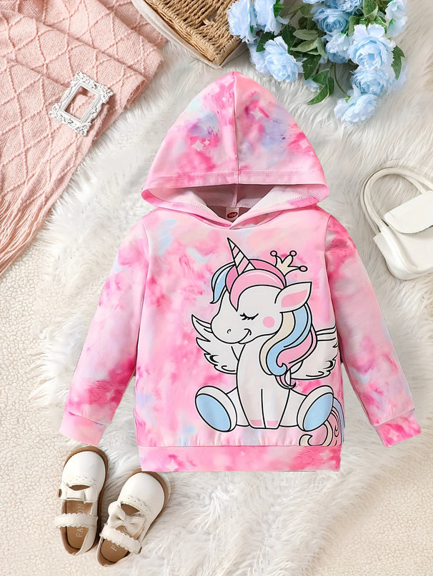 Mädchen in einem bunten Einhorn Hoodie mit Cartoon-Motiv, spielt fröhlich draußen. Ideal für den Frühling.