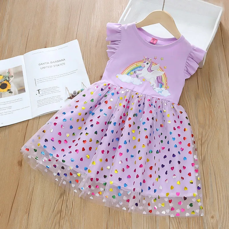 Mädchen in einem lilafarbenen Riesen Einhorn Regenbogenkleid mit fliegenden Ärmeln und einem schimmernden Mesh-Rock, in einer verträumten Pose.