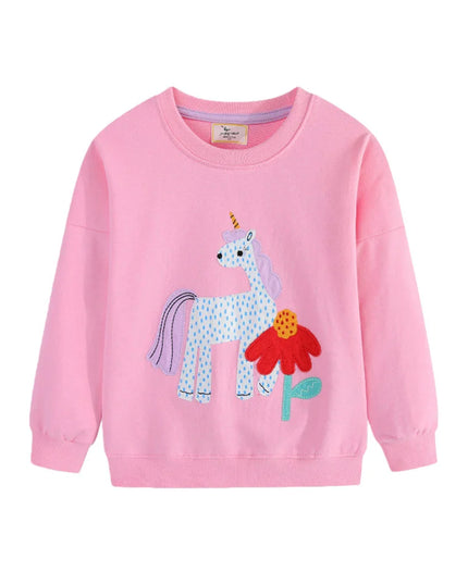 Mädchen in einem lila Riesen Einhorn Langarm Sweatshirt mit einem verspielten Einhorn-Motiv auf der Vorderseite, lächelnd und fröhlich.