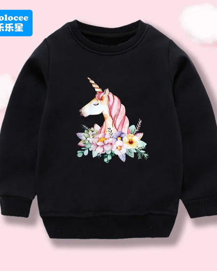 Mädchen trägt schwarzen Einhorn Hoodie mit einem detailreichen Cartoon-Blumen-Einhorn-Motiv und einem entspannten Lächeln